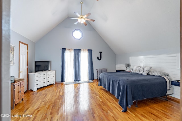 bedroom with light hardwood / wood-style floors, vaulted ceiling, and ceiling fan