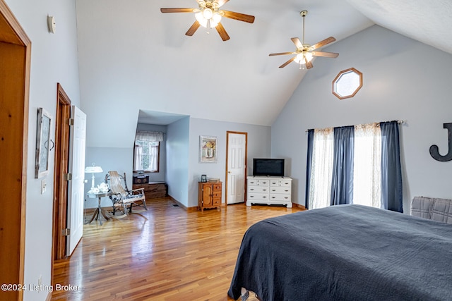 bedroom featuring light hardwood / wood-style floors, high vaulted ceiling, and ceiling fan