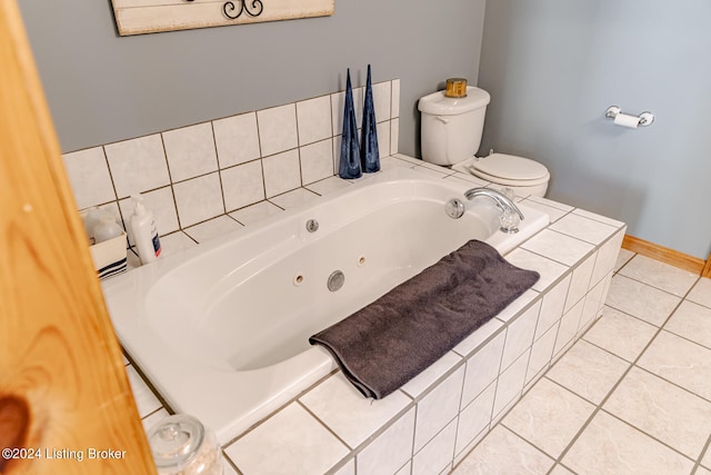 bathroom with toilet, tile patterned floors, and tiled bath