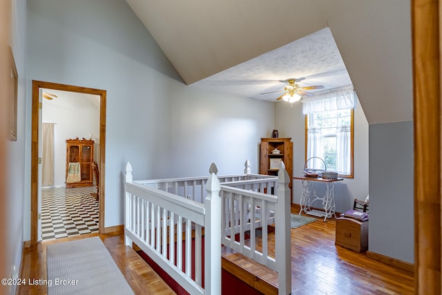 bedroom featuring vaulted ceiling, wood-type flooring, a crib, and ceiling fan