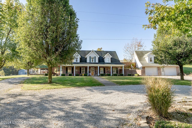 cape cod home with a porch, a front yard, and a garage