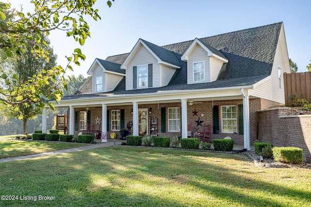 cape cod-style house featuring covered porch and a front yard