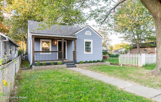 bungalow featuring central AC unit, a front yard, and covered porch