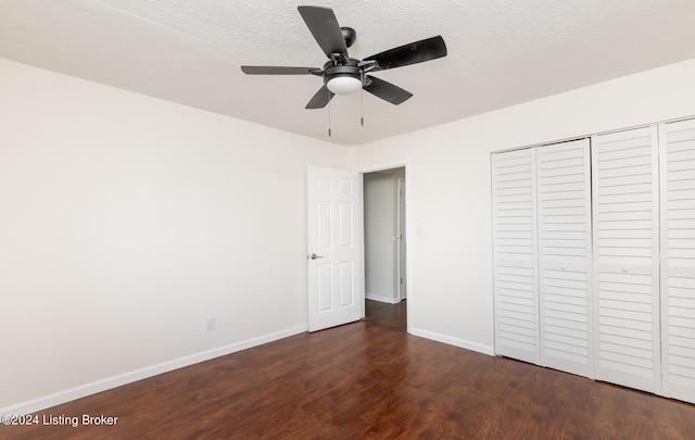 unfurnished bedroom with dark hardwood / wood-style flooring, a closet, a textured ceiling, and ceiling fan