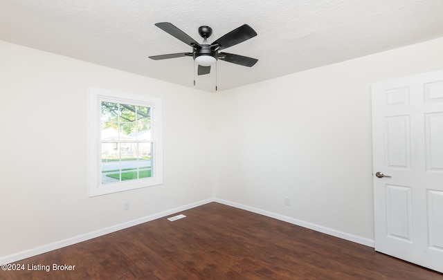 spare room with a textured ceiling, dark wood-type flooring, and ceiling fan