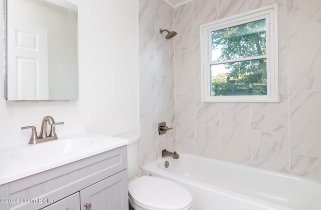 full bathroom featuring vanity, tiled shower / bath, and toilet