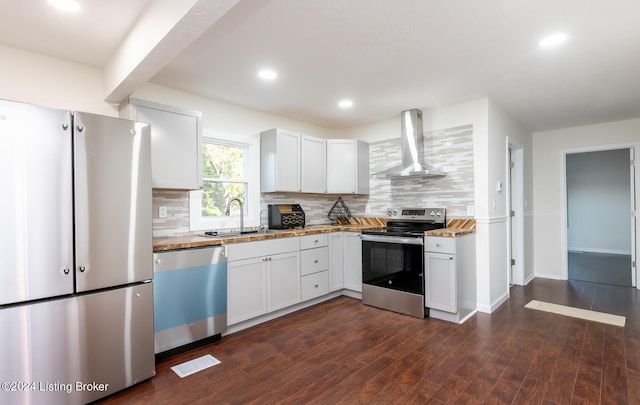 kitchen with stainless steel appliances, wall chimney exhaust hood, white cabinetry, and dark wood-type flooring