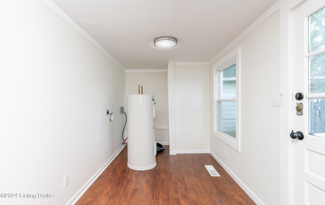 laundry room with dark hardwood / wood-style flooring, a textured ceiling, electric water heater, and ornamental molding