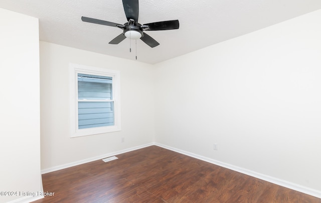 empty room with dark wood-type flooring, ceiling fan, and a textured ceiling