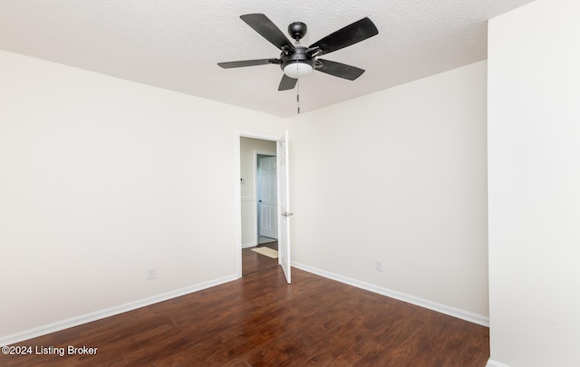 empty room featuring dark wood-type flooring, ceiling fan, and a textured ceiling