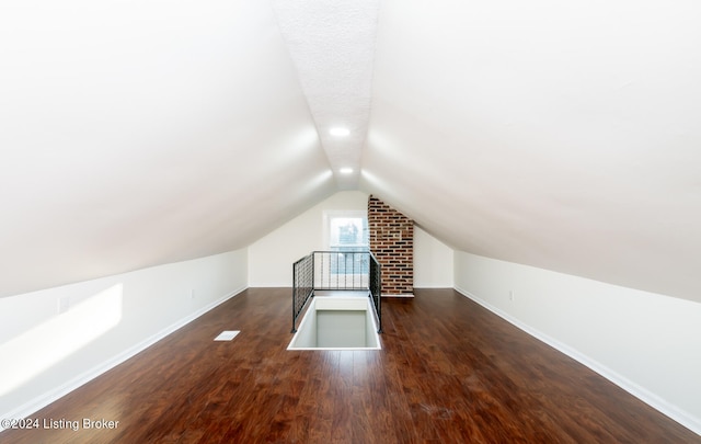 bonus room with vaulted ceiling and dark hardwood / wood-style floors