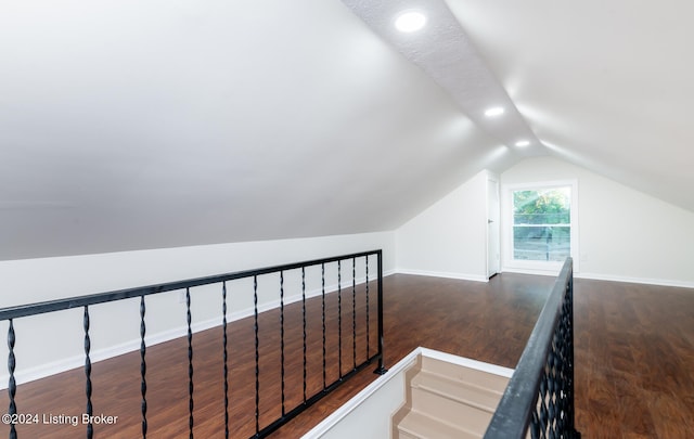 stairway featuring wood-type flooring and lofted ceiling