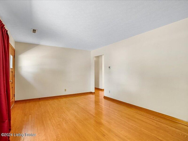 empty room featuring light hardwood / wood-style flooring and a textured ceiling