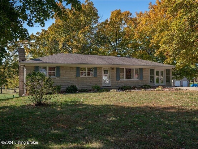 ranch-style house with a shed and a front lawn