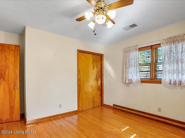 unfurnished room featuring light hardwood / wood-style floors, a textured ceiling, and ceiling fan