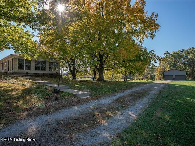 view of front of home with a front yard, a garage, and an outdoor structure