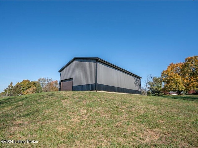 view of home's exterior featuring an outdoor structure, a garage, and a lawn