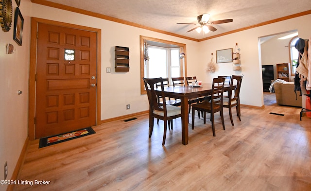 dining area featuring ceiling fan, crown molding, a textured ceiling, and light hardwood / wood-style floors