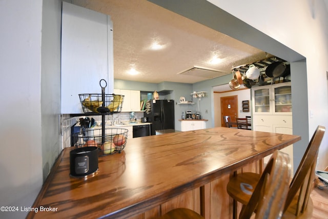 dining area with light hardwood / wood-style floors and a textured ceiling