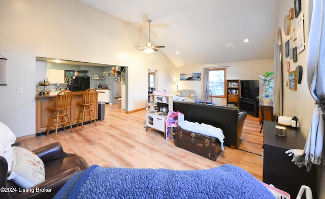 living room with high vaulted ceiling, light wood-type flooring, and ceiling fan