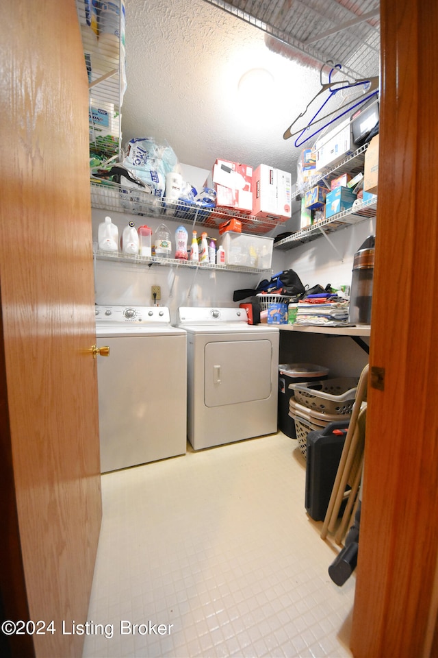 washroom featuring a textured ceiling, light tile patterned flooring, and washing machine and dryer