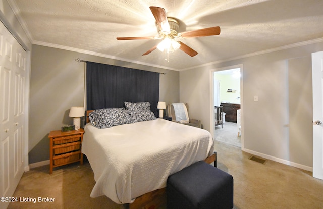 carpeted bedroom featuring a closet, ceiling fan, crown molding, and a textured ceiling