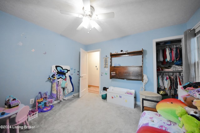 playroom featuring ceiling fan, light carpet, and a textured ceiling