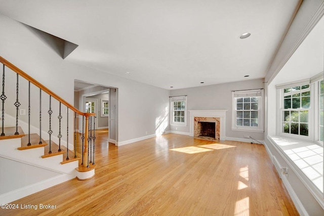 unfurnished living room with a fireplace and light hardwood / wood-style floors