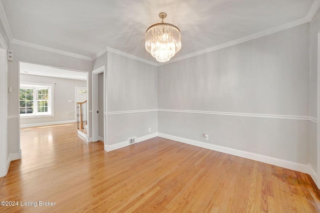 unfurnished room with crown molding, a notable chandelier, and light wood-type flooring