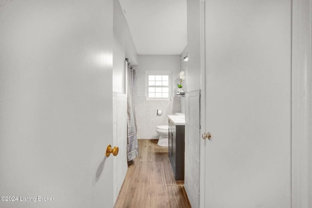 bathroom with tile walls, vanity, hardwood / wood-style flooring, and toilet