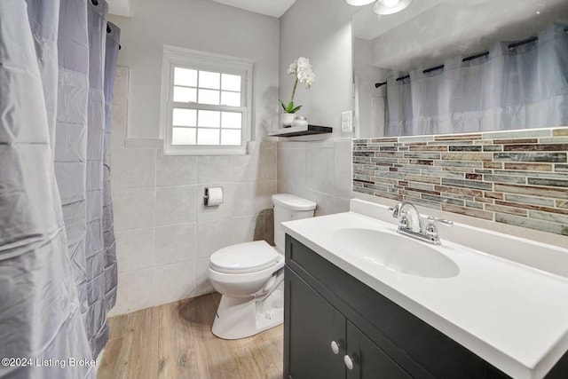 bathroom featuring toilet, vanity, wood-type flooring, and tile walls