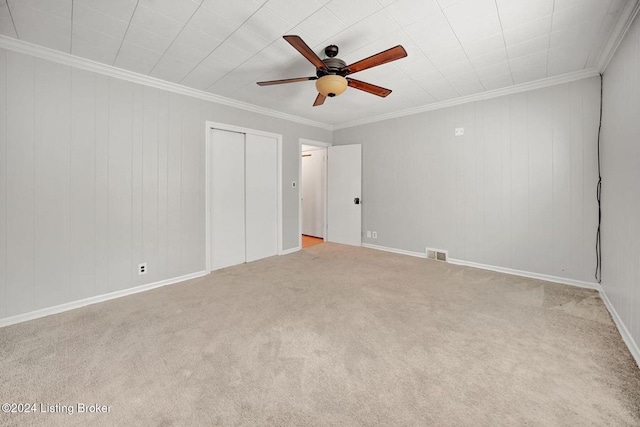 unfurnished bedroom with crown molding, light carpet, a closet, and ceiling fan