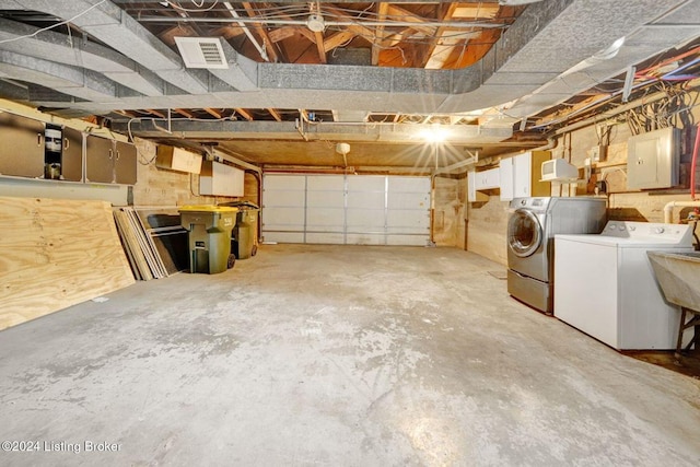 garage featuring electric panel and washer and clothes dryer