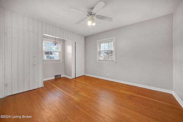 unfurnished room with hardwood / wood-style floors, plenty of natural light, and ceiling fan