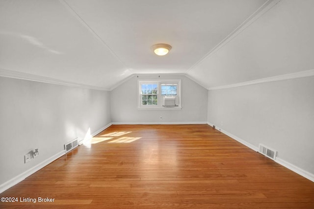 additional living space featuring vaulted ceiling and light wood-type flooring