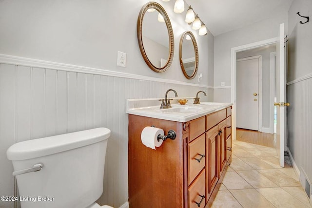 bathroom with toilet, vanity, and tile patterned floors