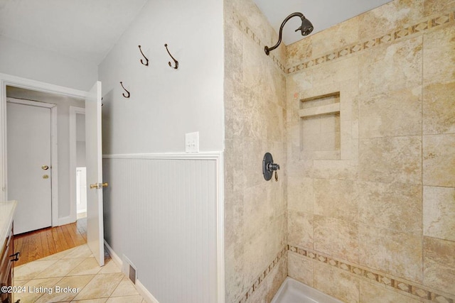 bathroom with vanity, hardwood / wood-style floors, and tiled shower