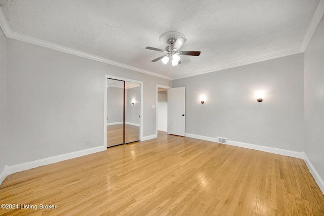 unfurnished bedroom featuring ornamental molding, a textured ceiling, light wood-type flooring, and ceiling fan