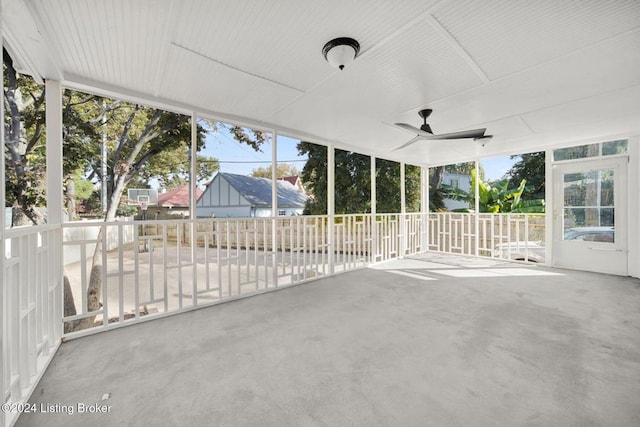 unfurnished sunroom with ceiling fan