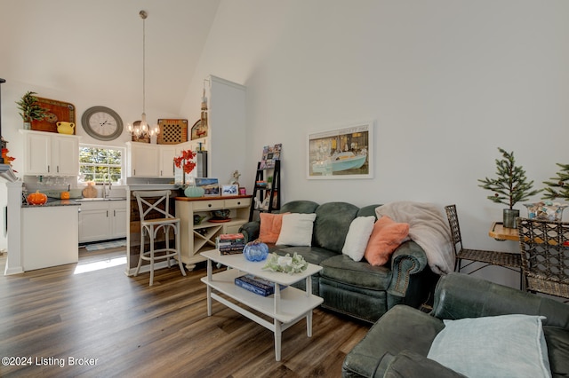 living room featuring a chandelier, high vaulted ceiling, dark wood-type flooring, and sink