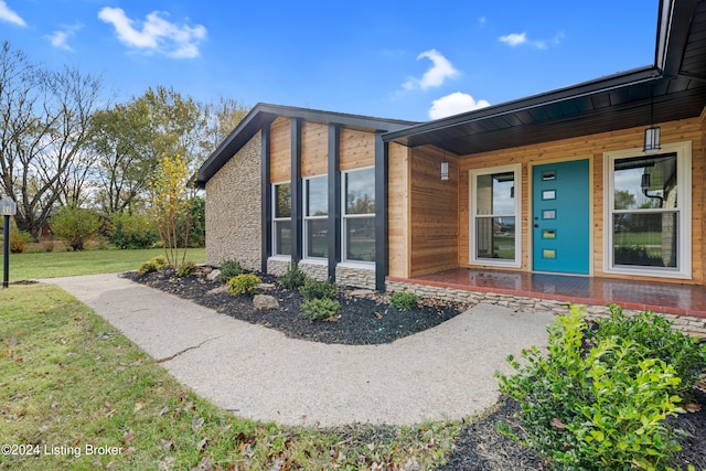 doorway to property featuring a yard