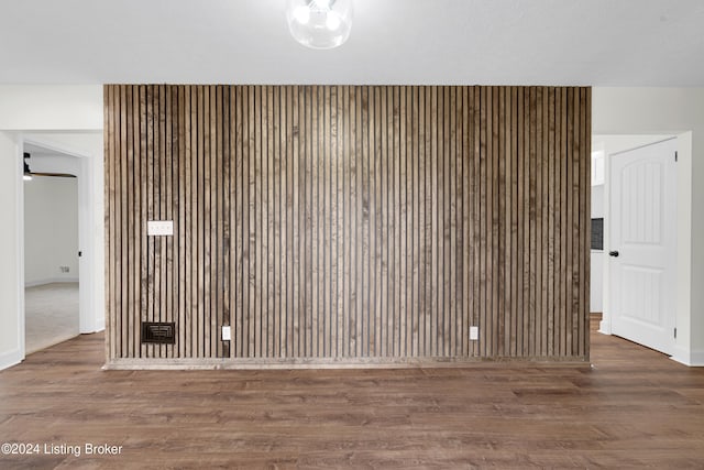 room details featuring hardwood / wood-style floors and wooden walls