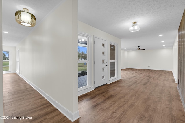 foyer with ceiling fan, a textured ceiling, and dark hardwood / wood-style floors