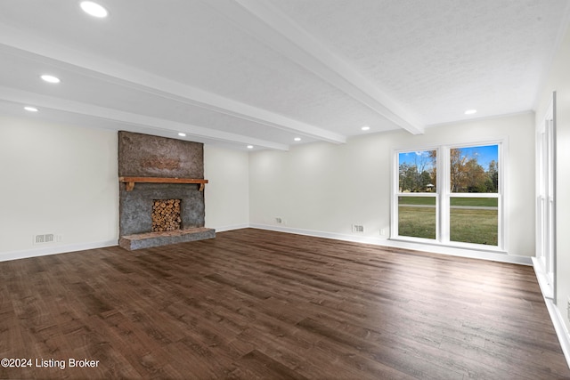 unfurnished living room featuring dark hardwood / wood-style flooring, a large fireplace, and beam ceiling