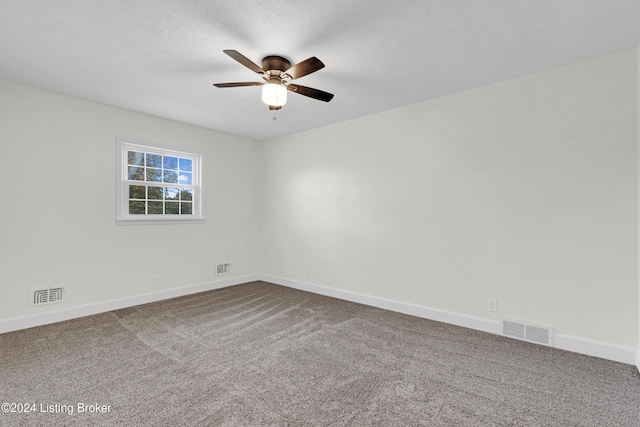 carpeted spare room featuring a textured ceiling and ceiling fan