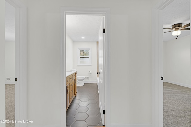 bathroom featuring ceiling fan, a textured ceiling, vanity, tile patterned floors, and toilet