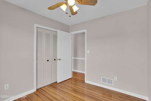 unfurnished bedroom featuring light hardwood / wood-style flooring, a closet, and ceiling fan