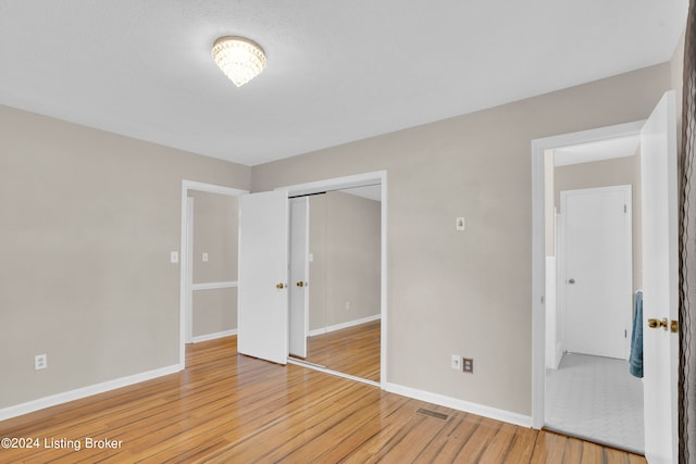 unfurnished bedroom with a closet and hardwood / wood-style flooring