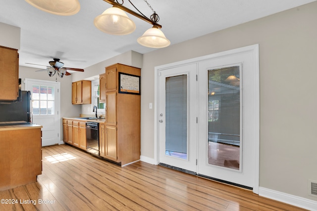 kitchen with black appliances, sink, light wood-type flooring, and pendant lighting