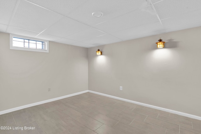 basement with a paneled ceiling